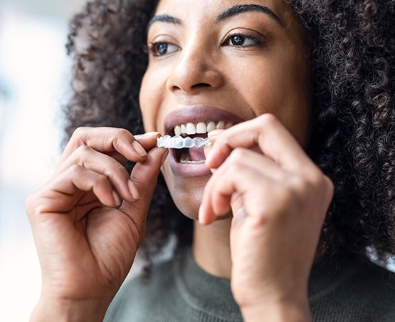 Adult female inserting a clear aligner