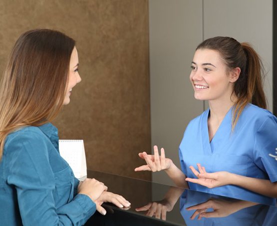a front desk member talking to a patient’s parent
