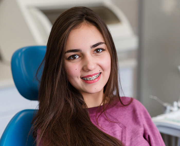 Teen with traditional orthodontics smiling