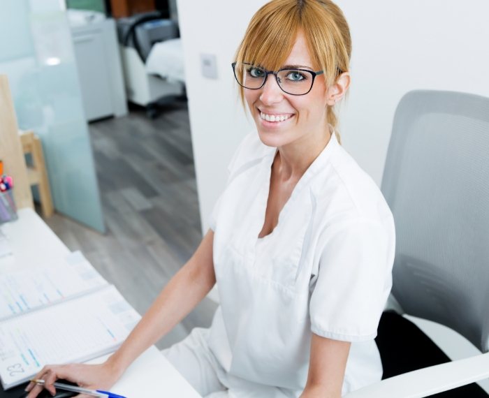 Friendly dental team member at dental office reception desk