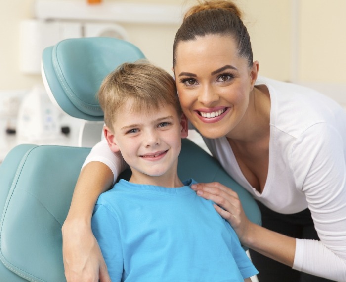 Child and parent smiling after silver diamine fluoride treatment