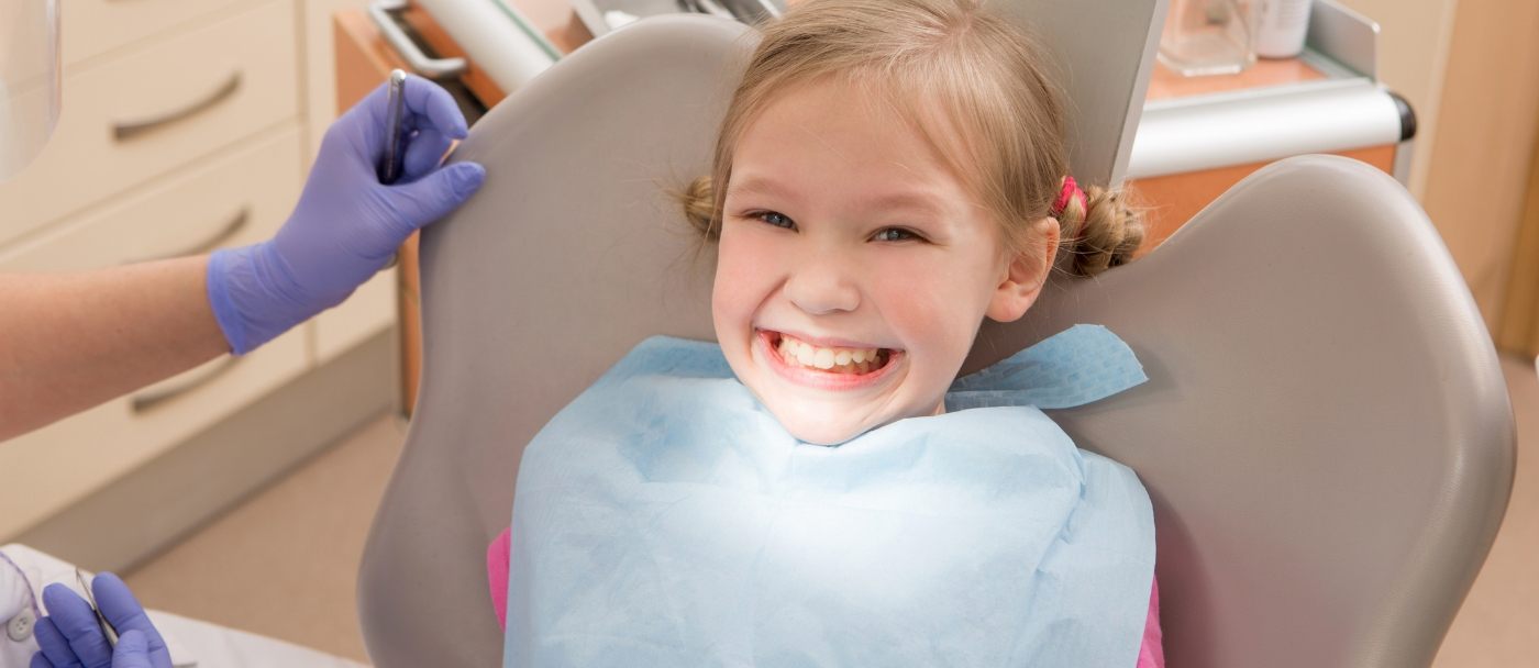 Child smiling while receiving dental services