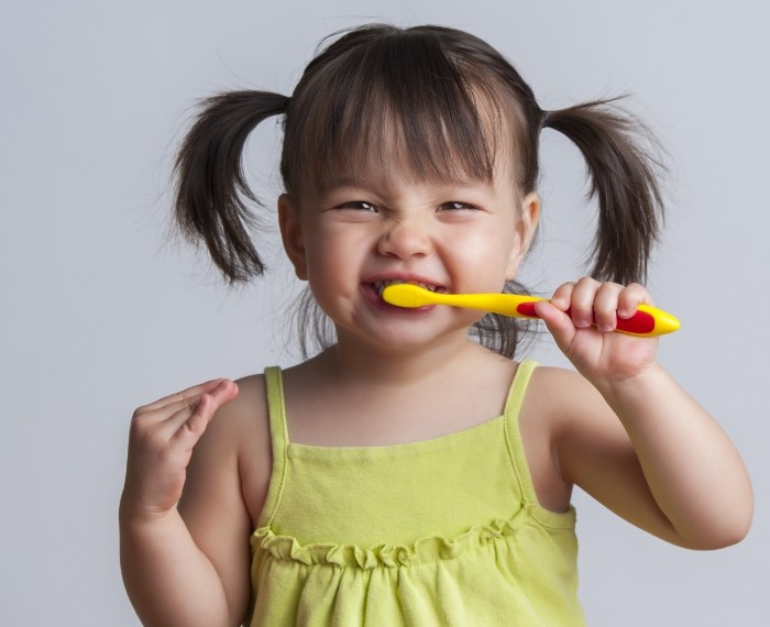 Child brushing teeth to prevent dental emergencies