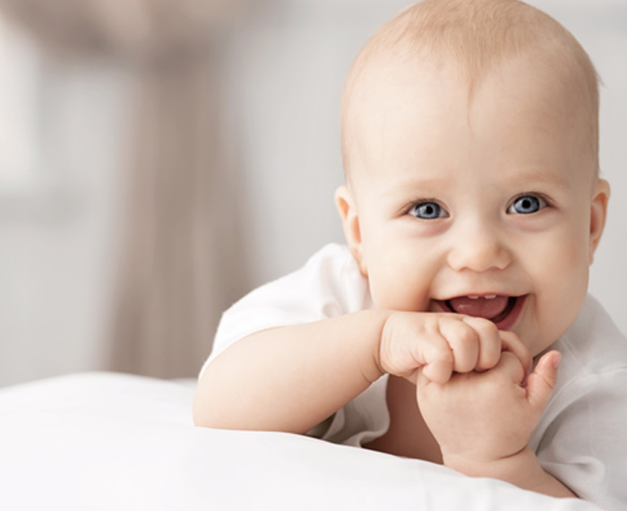 Happy, smiling baby on pillow