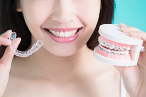 a patient holding Invisalign and a model of braces