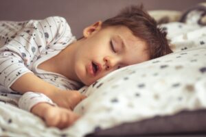 Young boy sleeping in bed, snoring 